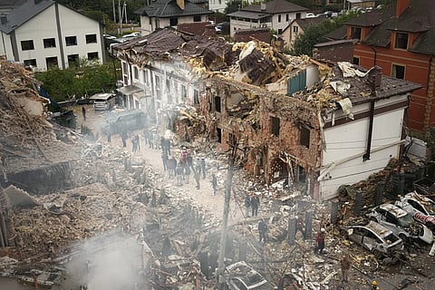 People seen at the site of an apartment building destroyed during a Russian attack in Kyiv, Ukraine, Sunday, Sept. 28, 2025.