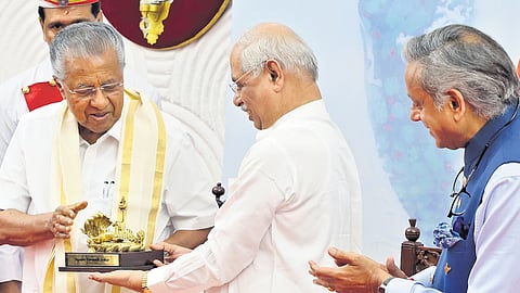 Governor Rajendra Arlekar presents a memento to Chief Minister Pinarayi Vijayan during the releasing function of ‘Rajahams’, the in-house journal of Kerala Raj Bhavan, on Sunday. MP Shashi Tharoor is also seen