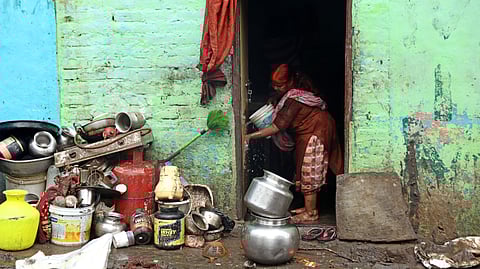 A woman cleans her residence at Musinagar near Chaderghat bridge in Hyderabad.