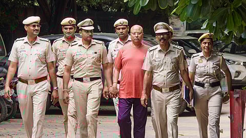 Self-styled godman Chaitanyananda Saraswati, who allegedly sexually harassed 17 women students at a private institute in Agra, being escorted by police personnel after his arrest, at Vasant Kunj police station, in New Delhi, Sunday, Sept. 28, 2025.