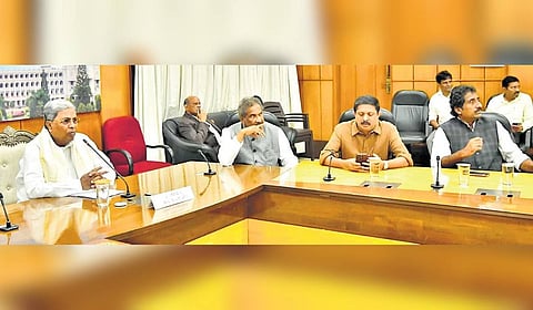 Chief Minister Siddaramaiah holds a meeting with ministers and officials of various civic agencies and departments at his home office Krishna on Monday.