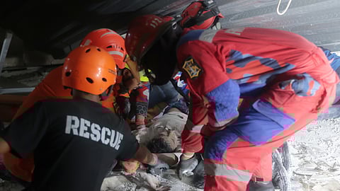 Rescuers pull out a survivor from a collapsed building at an Islamic boarding school in Sidoarjo, East Java, Indonesia, Monday, Sept. 29, 2025.