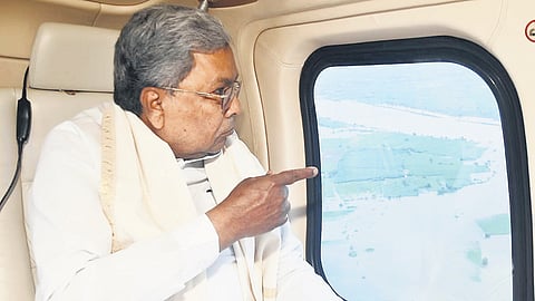 CM Siddaramaiah looks at the devastation in North Karnataka from a helicopter, during an aerial survey of the flood-affected areas on Tuesday.