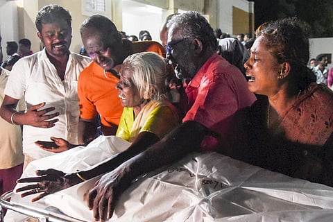 Family members mourn as they receive the body of a victim from the TVK rally in Karur