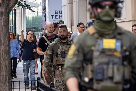Pedestrians chant, "ICE go home!" as federal immigration agents walk along North Clark Street in the River North neighborhood, Sunday, Sept. 28, 2025, in Chicago.