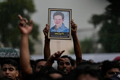A fan holds a photograph of the popular Bollywood singer and composer Zubeen Garg during the homage ceremony in Guwahati, Sunday, Sept. 21, 2025