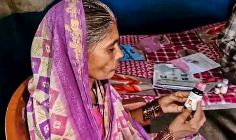 An elderly woman looks at a bottle of Coldrif cough syrup, in Betul, Madhya Pradesh, Sunday, Oct. 5, 2025. The state government has banned the sale of the cough syrup following the death of over 13 children due to suspected renal failure.