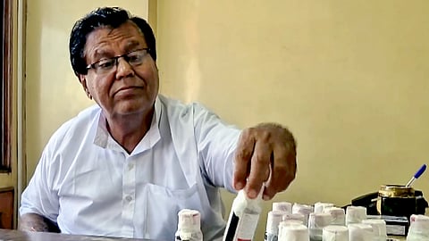 An official looks at bottles of the Coldrif cough syrup after a raid by the Drug and Pharmaceuticals Department officials at Kataria Pharmaceuticals, after the deaths of 11 children.