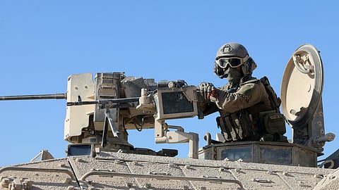 This picture taken during a media tour organised by the Israeli army shows an Israeli army soldier behind a mounted machine gun in the vicinity of the Jordanian Field Hospital in Gaza City, Friday, Oct. 3, 2025.