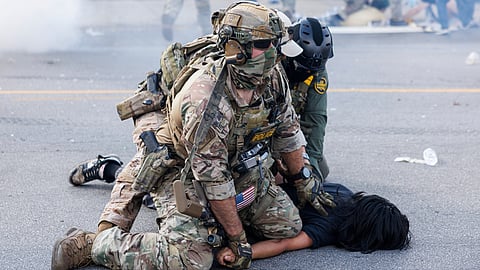 Federal officers hold down a protestor in the Brighton Park neighborhood of Chicago, on Saturday, Oct. 4, 2025, after protesters learned that U.S. Border Patrol shot a woman Saturday morning on Chicago's Southwest Side.