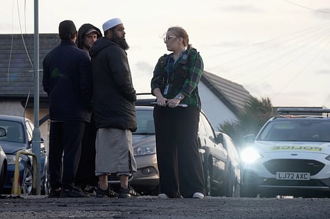 Locals view the damage outside the front entrance of the mosque in Peacehaven, following a suspected arson attack, in East Sussex, England, Sunday, Oct. 5, 2025.