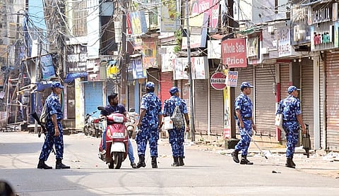 Security personnel patrol a street during curfew in Cuttack.