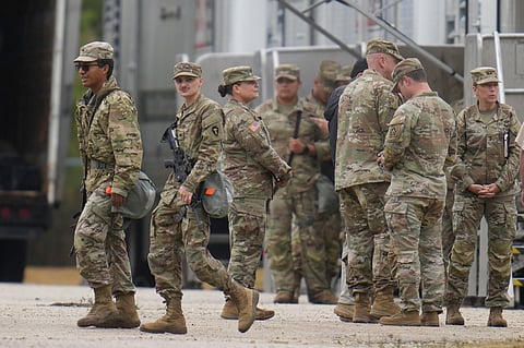 Military personnel in uniform, with the Texas National Guard patch on, are seen at the U.S. Army Reserve Center, Tuesday, Oct. 7, 2025, in Elwood, Ill., a suburb of Chicago.