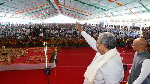 Chief Minister Siddaramaiah waves to supporters in Koppal on Monday. Minister Dr Sharan Prakash Patil is also seen.