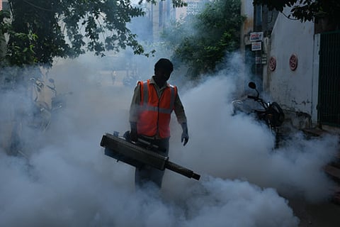 A municipal corporation worker fumigates streets and drains to contain bacteria and mosquito larvae in Vijayawada on Wednesday.
