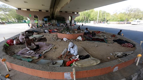 Homeless people sit under a flyover during a nationwide curfew imposed to prevent the spread of the coronavirus in New Delhi on Wednesday.