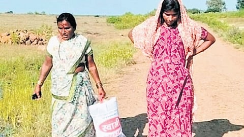 A pregnant woman navigates a muddy road in Kangti to reach an ambulance