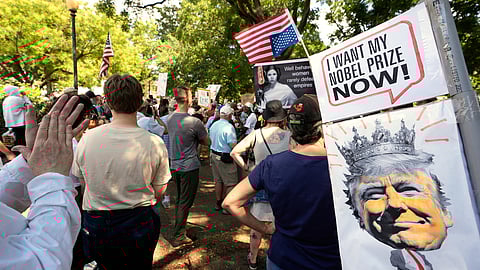 Activists carry signs during a protest against President Donald Trump's federal takeover of policing of the District of Columbia, Saturday, Aug. 16, 2025, in Washington.