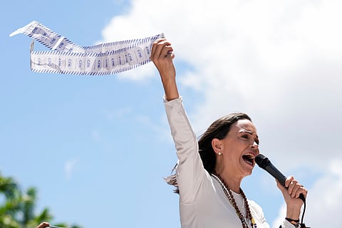 Opposition leader Maria Corina Machado holds up tally sheets during a protest against the reelection of President Nicolás Maduro one month after the disputed presidential vote which she says the opposition won by a landslide, in Caracas, Venezuela, Aug. 28, 2024.