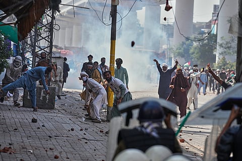 Supporters of the Islamist party 'Tehreek-e-Labbaik Pakistan' throw stones toward police during clashes ahead of their pro-Palestinian march toward capital Islamabad, in Lahore, Pakistan, Friday, Oct. 10, 2025.