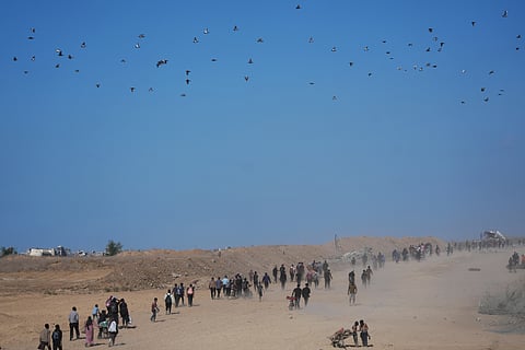 Displaced Palestinians walk toward Gaza City, in the northern Gaza Strip, Friday, Oct. 10, 2025, after Israel and Hamas agreed to a pause in their war and the release of the remaining hostages.