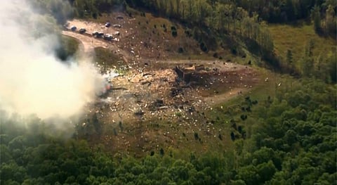 Smoke fills the air as debris covers the ground and vehicles after a powerful blast ripped through a military explosives manufacturing plant in Hickman County, Tenn., on Friday, Oct. 10, 2025.
