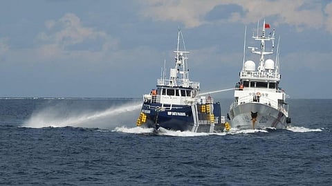 In this photo provided by the Philippine Coast Guard, a Chinese Coast Guard vessel, right, fires its water cannon at the Philippines' BRP Datu Pagbuaya near Philippine-occupied Thitu Island, locally called Pag-asa Island, in the South China Sea on Sunday, Oct. 12, 2025.