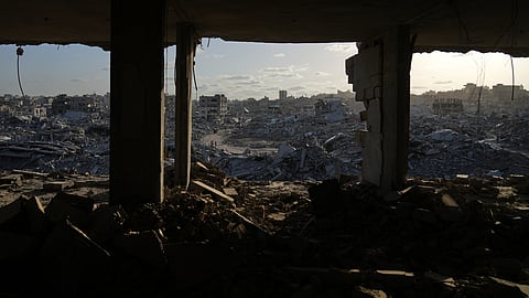Displaced Palestinians walk amid destroyed buildings in the heavily damaged Sheikh Radwan neighborhood in Gaza City, Saturday, Oct. 11, 2025, after Israel and Hamas agreed to a pause in their war and the release of the remaining hostages.