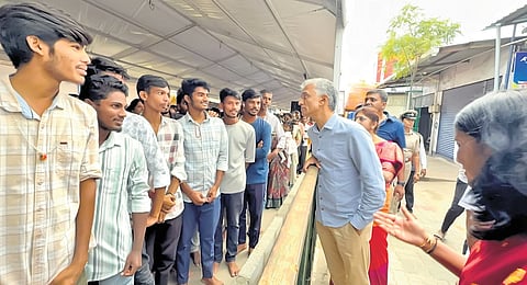 District in-charge Minister Krishna Byre Gowda interacts with students who came to visit the Hasanamba temple in Hassan on Sunday