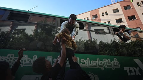 A Palestinian released from Israeli prisons under a Gaza ceasefire and hostage exchange deal with Palestinian factions, greets a relative as he arrives on a bus outside the Nasser hospital in Khan Yunis in the southern Gaza Strip on October 13, 2025