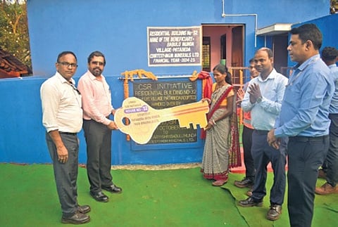 Nenival handing over the key of a residential building to a beneficiary at Patabeda village