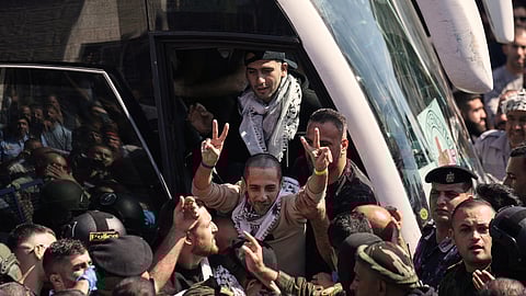 A Palestinian prisoner makes the victory sign after being released from an Israeli prison as part of a ceasefire deal between Israel and Hamas, upon his arrival in the West Bank city of Ramallah, Monday, Oct. 13, 2025.