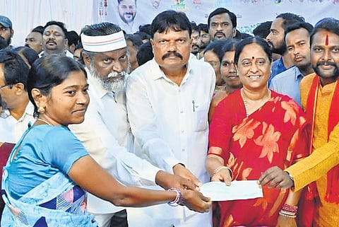 Endowments Minister Konda Surekha hands over cheques to beneficiaries of various schemes in Warangal on Tuesday
