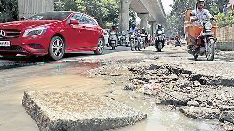 A protruding concrete slab and overflowing sewage pose a risk for motorists on the busy Bannerghatta Road in Bengaluru.