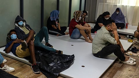 Alleged scam centre workers and victims rest during a crackdown operation by the Karen Border Guard Force (BGF) on illicit activity in Shwe Kokko in Myanmar's eastern Myawaddy township on February 18, 2025.