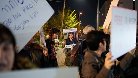A woman holds a sign with a photo of Palestinian Dr. Hussam Abu Safiya during a protest calling for his release in front of the Shin Bet offices in Tel Aviv, Israel, Jan. 1, 2025.