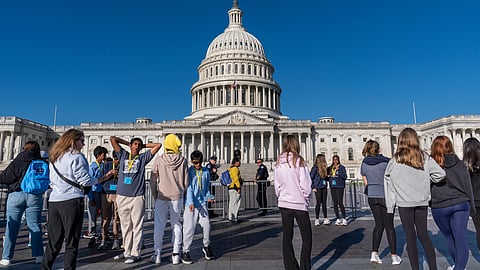 Students from Columbus, Ohio, wait outside a barrier as U.S. Capitol Police watch over the East Plaza where congressional leaders will have a news conferences on the government shutdown at the Capitol in Washington, Wednesday, Oct. 15, 2025.