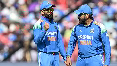 India's Virat Kohli (L) speaks with his captain Rohit Sharma during the second ODI cricket match between India and England at the Barabati Stadium in Cuttack on February 9, 2025.