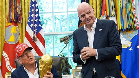 US President Donald Trump holds the FIFA World Cup Winners Trophy as FIFA President Gianni Infantino looks on during an announcement in the Oval Office of the White House, Aug. 22, 2025, in Washington.