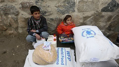 Children wait for transportation after receiving food donated by the World Food Program, in Kabul, Afghanistan, Jan. 24, 2017.