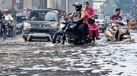 Motorists passing through a flooded Madipakkam Main Road in Chennai on Tuesday morning