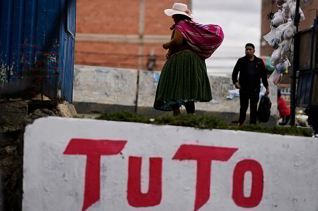 A woman walks past a mural promoting presidential candidate Jorge "Tuto" Quiroga ahead of the runoff election in El Alto, Bolivia, Thursday, Oct. 16, 2025.
