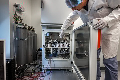 FinalSpark's lab co-founder Fred Jordan shows devices containing human brain cells inside a laboratory refrigerator in Vevey, on October 3, 2025.