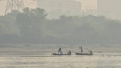 People catch fish in the Yamuna river amid smog, at Kalindi Kunj, in New Delhi, Saturday, Oct. 18, 2025. Delhi's Air Quality Index (AQI) remained in the 'poor' category, with a reading of 252 at 9 am, on Saturday.