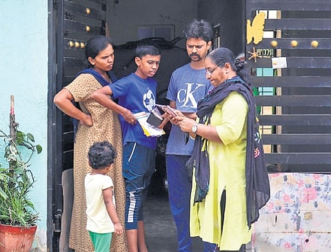 An enumerator collects details from a family during the socio-economic survey in Horamavu.