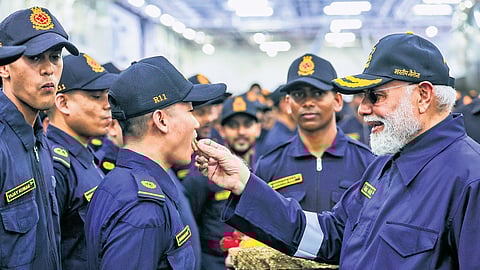 Prime Minister Narendra Modi offers sweets to naval personnel aboard INS Vikrant during his Diwali visit, off the coast of Goa and Karwar on Monday.