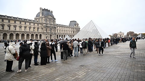 Soldiers patrol as people queue to try to enter the Louvre museum, although it remains closed for the day after Sunday's jewels robbery, Monday, Oct. 20, 2025 in Paris