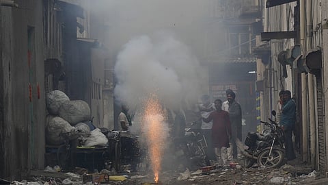 People light firecrackers as part of Diwali festival celebrations, even as pollution levels surged across Delhi-NCR, with Wazirpur recording severe air quality, in New Delhi, Tuesday, Oct. 21, 2025.