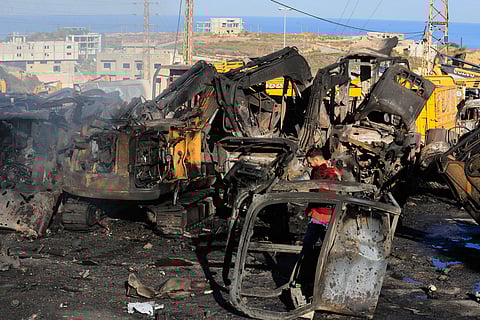A man walks at a site that sold heavy machinery, where a large number of vehicles were destroyed in Israeli airstrikes, in the southern village of Msayleh, Lebanon, Saturday, Oct. 11, 2025.
