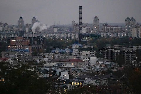 Smoke bellows in the background at dusk in Kyiv, Ukraine, Tuesday, Oct. 21, 2025.